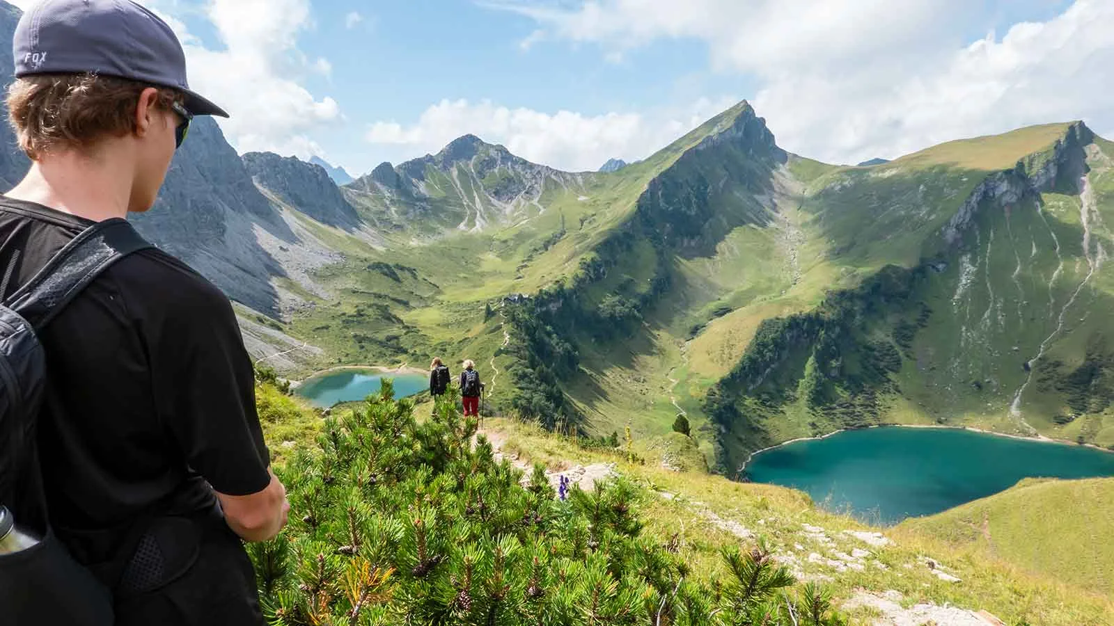 Wanderer blickt auf alpine Bergseen und Gipfel